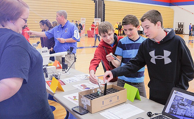 Alycia Stroup discusses chemical analysis with California High School freshmen Austin Oswald, Collin Green and Tanner Booker at the Missouri Department of Natural Resources booth Friday at the school's career fair.
