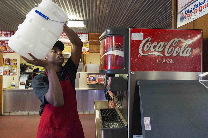 Montray Biddle, a student at Arkansas High School, refills ice Thursday at Big Jake's Bar-B-Que on Arkansas Boulevard. Montray works at the restaurant as part of a school program that helps students prepare for the future.