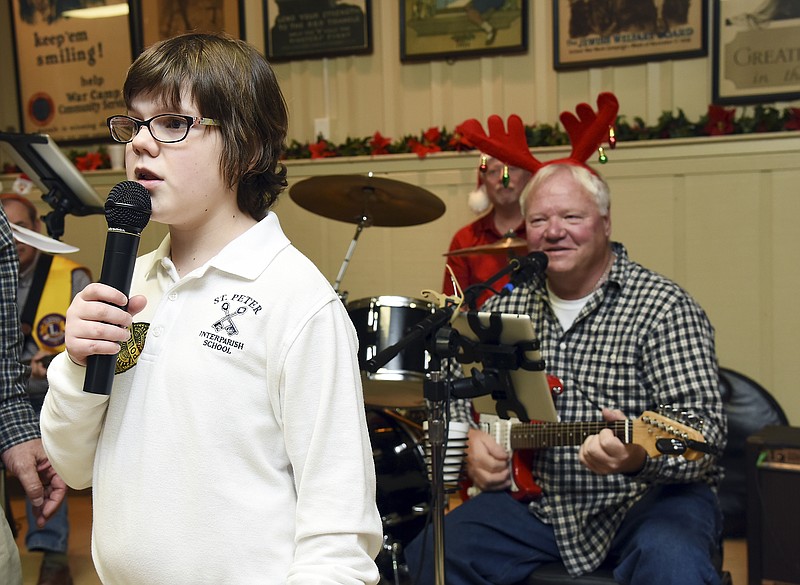 Gary Kempker dons reindeer antlers and plays backup to a singing Elaina Verslues, who took control of the microphone as much as she could to sing holiday songs, at Tuesday's Special Needs Christmas Party at American Legion Post 5. Verslues is a student at Vogelweid Learning Center at St. Peter Interparish School.