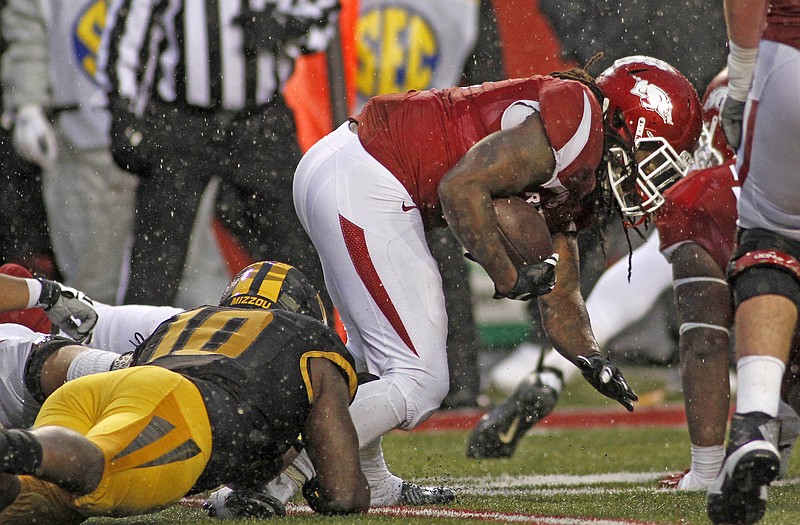 Missouri's Kentrell Brothers (10) brings down Arkansas' Alex Collins during a game Nov. 27 in Fayetteville, Ark.