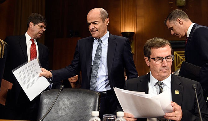 Anheuser-Busch InBev Chief Executive Officer Carlos Brito, second from left, walks past Brewers Association Chief Executive Officer Bob Pease, second from right, as he arrives to testify before the Senate Antitrust, Competition Policy and Consumer Rights Subcommittee on Capitol Hill in Washington, Tuesday, Dec. 8, 2015, before a hearing on the proposed $107 billion takeover by the world's largest brewer, Anheuser Busch InBev, of rival SABMiller. The combined company would control nearly a third of the global beer market.