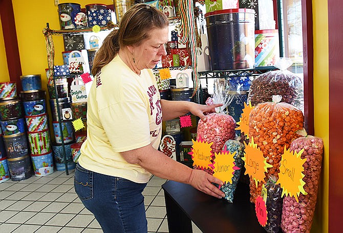 Popcorn Buddha owner, Tanya DeMaria, straightens the different size bags of popcorn available at her retail
store in Linn, Mo. The tasty concoctions are made in house with quality ingredients. Large batches of corn are popped and seasonings or coatings added and stored in plastic containers in view of the customers.