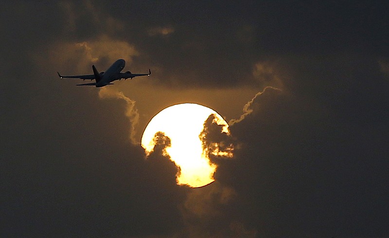 A plane takes off from Key West International Airport as the sun rises on Aug. 6, 2015, in Key West, Fla. Vacations are a great way to relax, reconnect with family and escape the daily grind of work. They can also quickly drain your savings account, but there are ways to save money. 