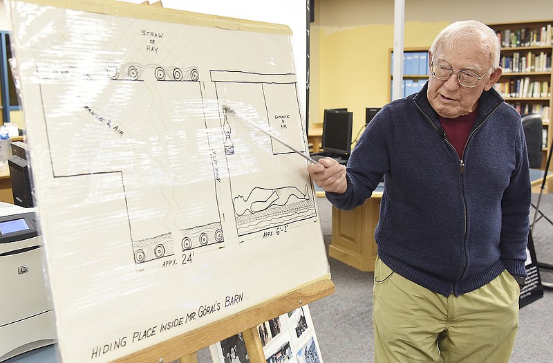 Jerry Koenig refers to a diagram of the dark and cramped quarters inside a barn, where 11 people survived while hiding from Nazi soldiers. He told Helias students about his experiences in the early-1940s in Poland. 