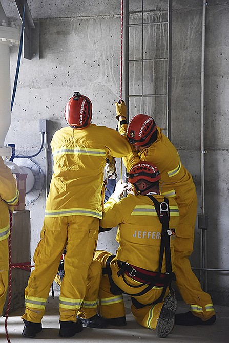 Members of the Jefferson City Fire Department's SORT (Special Operations Response Team) used the Missouri American Water Rockhill Tower Tuesday for training. Firefighters, including Chris McCray shown here, climbed the extreme vertical ladder to secure the victim to the fire department's rope system before the crew on the ground safely lowered the injured worker to the ground.