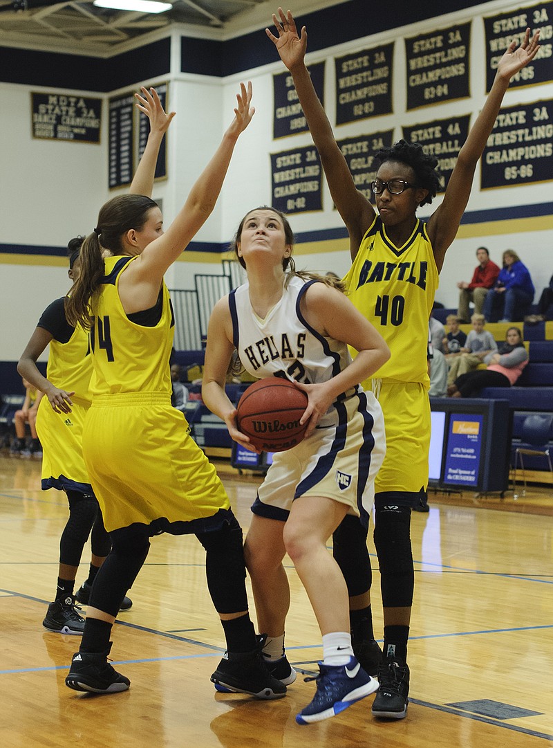 Erin Wyrick of Helias looks to the basket as she tries to split the defense of Battle's Elaine Miller (14) and Maya Mouton (40) during the third quarter of Monday night's game at Rackers Fieldhouse.