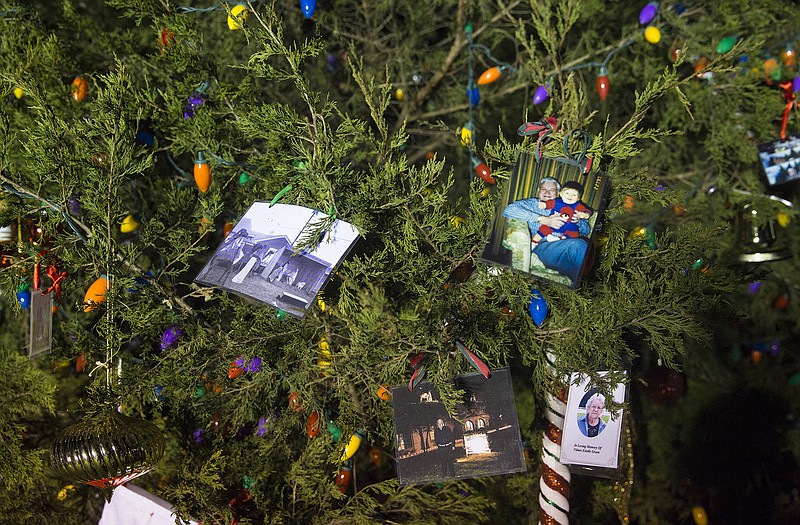 Photos and homemade ornaments pack the base of the Memory Tree at Houser Millard Funeral Directors Thursday before the first annual lighting of the tree. The tree, in memory of legendary Jefferson City Christmas decorator Jack Steppelman, is intended to be a place to honor loved ones who have passed away since last Christmas. 