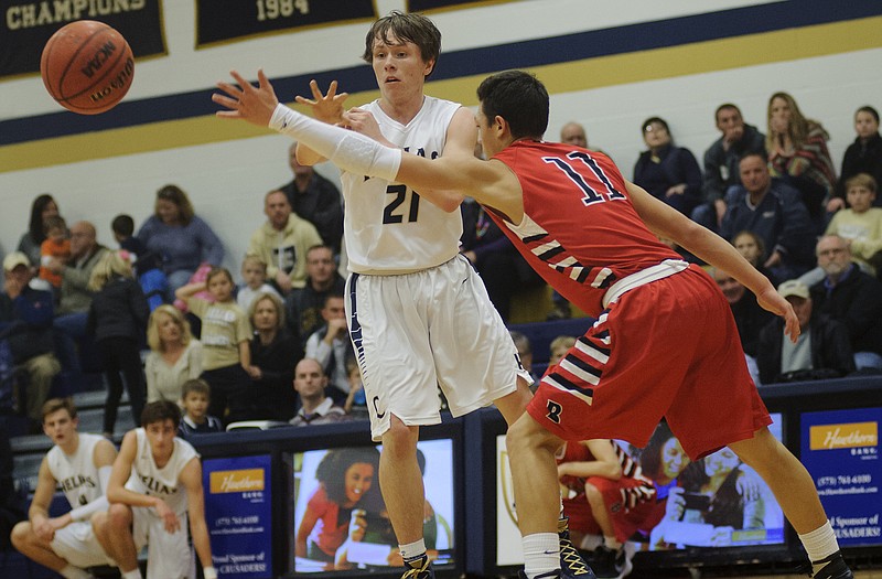 Helias guard Alex Brandt fires off a pass while orchestrating the Crusader offense from the top of the key against the defense of Branson's Collin Pepper during Friday night's game at Rackers Fieldhouse.