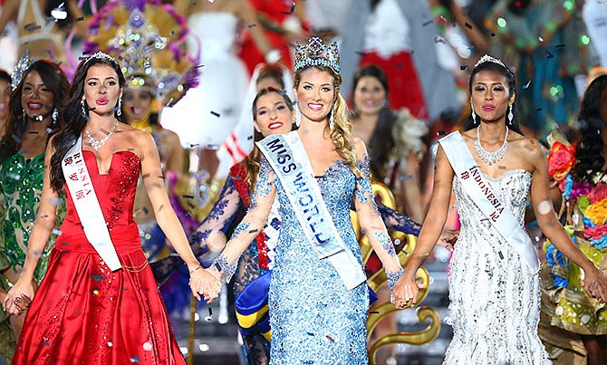 Miss World Mireia Lalaguna Royo from Spain, center, Sofia Nikitchuk from Russia, left, the runner-up, and Maria Harfanti from Indonesia, right, the second runner-up celebrate at the end of the 2015 Miss World Grand Final in Sanya in south China's Hainan province Saturday Dec. 19, 2015. Spain's Mireia Lalaguna Royo was named the winner of the Miss World 2015 competition Saturday night in the southern Chinese island resort of Sanya, an event dogged by controversy over China's refusal to allow Canada's entrant to attend. (Chinatopix Via AP)