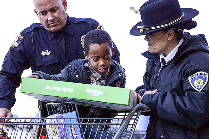 
Cameran Thomas, 7, center, focuses on his new castle play set alongside Sgt. Katie Feldman, right, of the
Missouri Department of Corrections, and David Mays, of the Jefferson City Police Department.