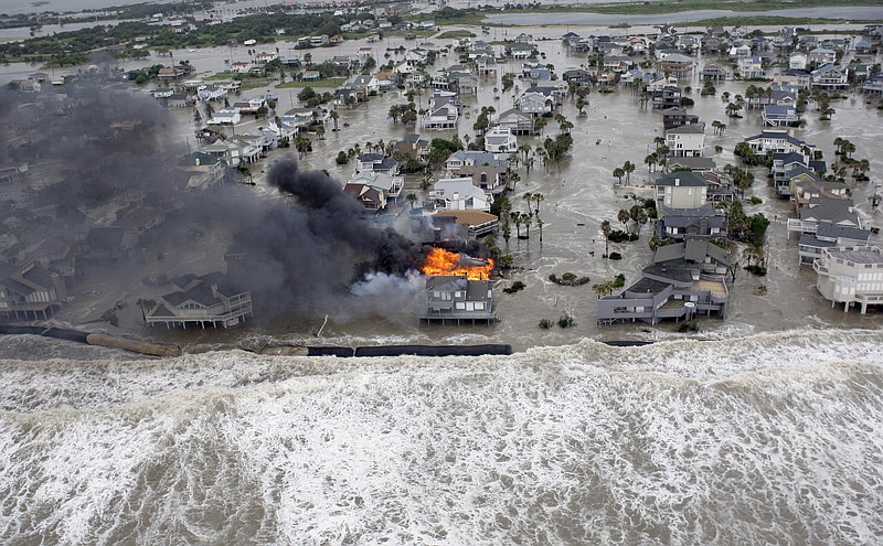 Fire destroys homes along the beach on Galveston Island, Texas, in 2008 as Hurricane Ike approaches. More than a third of the $3 billion in federal disaster recovery funds from hurricanes Ike and Dolly remains unspent seven and a half years after the storms battered the Texas coast, new state reports show.