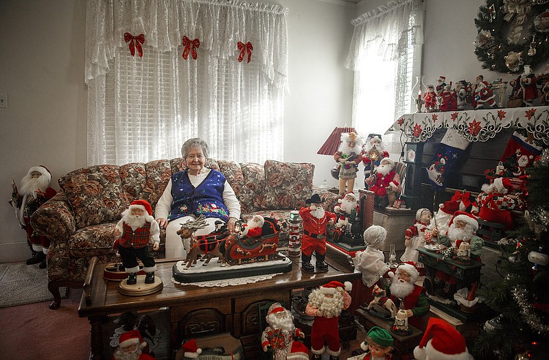 Rosemarie Sachs sits in her living room surrounded by her vast collection of Santas. 