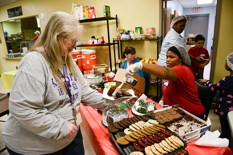 Tanesha Pulley, right, Salvation Army Volunteer, serves Tammey Sweezer fudge brownies for dessert during the Salvation Army Christmas Dinner. "This is a day I'm very grateful for," said Sweezer.