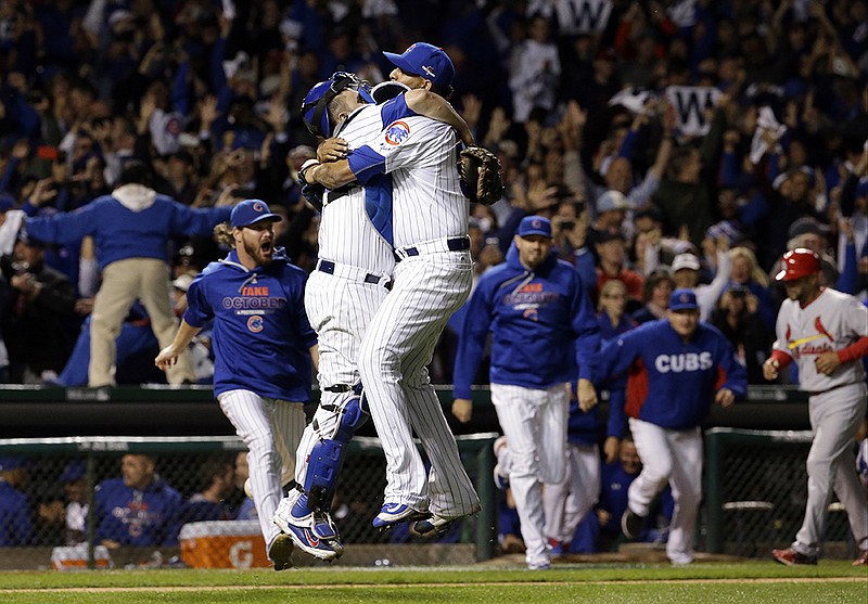 Chicago Cubs catcher Miguel Montero (47) and relief pitcher Hector Rondon (56) celebrate after winning Game 4 in baseball's National League Division Series on Oct. 13, 2015, in Chicago. While The Associated Press' Jim Litke hates draining the suspense from 2016 even before it begins, in a humorous prediction he says the Cubs winning the World Series will be the biggest story during the coming year in sports. 