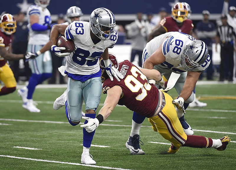 Dallas Cowboys wide receiver Terrance Williams fights off a tackle by Washington Redskins outside linebacker Trent Murphy during the first half Sunday in Arlington, Texas.