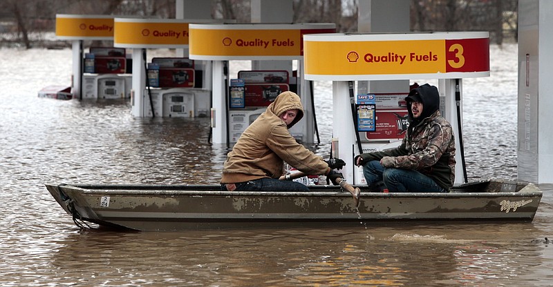 Paul Dusablon, left, and Richard Kotva row from the Circle K at Springdale Park on Dec. 30 after helping the owner move electronics off the floor inside the convenience store in Fenton. As scenic as the Mississippi River may appear, the latest bout of Midwest flooding has left it anything but a picture of purity downstream from St. Louis.