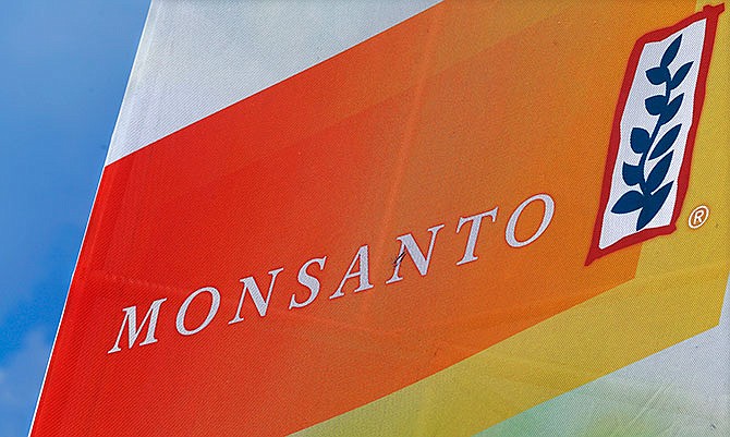 This Monday, Aug. 31, 2015, file photo, shows the Monsanto logo at the Farm Progress Show in Decatur, Ill. Monsanto on Wednesday, Jan. 6, 2016, said it swung to a $253-million loss in the first fiscal quarter, amid foreign currency pressures and falling sales of its biotech-enhanced corn seeds.