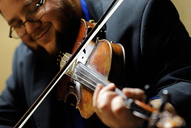 Fiddle player Hunter Berry warms up backstage as The Rage gets to take the stage with bluegrass superstar Rhonda Vincent for their 2015 performance during the opening day of the 41st annual Society for the Preservation of Bluegrass Music of America Bluegrass Music Awards and 32nd annual Midwest Convention at the Capitol Plaza Hotel in Jefferson City.
