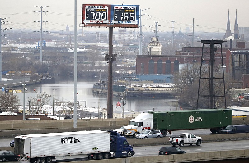 Motorists traveling on the interstate highway near downtown Chicago pass by an electronic billboard of the current jackpots for the Powerball and Mega-Millions lotteries, Thursday in Chicago.
