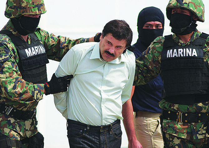 Joaquin "El Chapo" Guzman is escorted to a helicopter in handcuffs by Mexican navy marines in February 2014 at a navy hanger in Mexico City, Mexico. Mexican President Enrique Pena Nieto posted on his Twitter account Friday  that drug lord Joaquin 'Chapo' Guzman has been recaptured. 