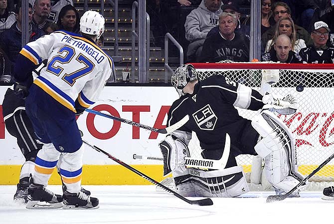 St. Louis Blues defenseman Alex Pietrangelo, left, scores on Los Angeles Kings goalie Jonathan Quick during the second period of an NHL hockey game, Saturday, Jan. 9, 2016, in Los Angeles. 