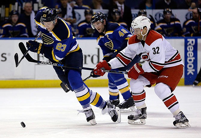 St. Louis Blues' Dmitrij Jaskin, left, of Russia, and Carolina Hurricanes' Kris Versteeg (32) chase after the puck as Blues' David Backes, center, watches during the second period of an NHL hockey game Thursday, Jan. 14, 2016, in St. Louis.