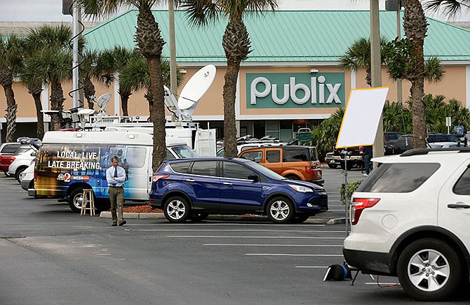 TV news trucks line the parking lot at a Publix Super Market, Thursday, Jan. 14, 2016, in Melbourne Beach, Fla., where one of three winning tickets in the record Powerball jackpot was sold. The holder of the winning ticket will share the $1.6 billion jackpot with winners in Southern California and Tennessee.