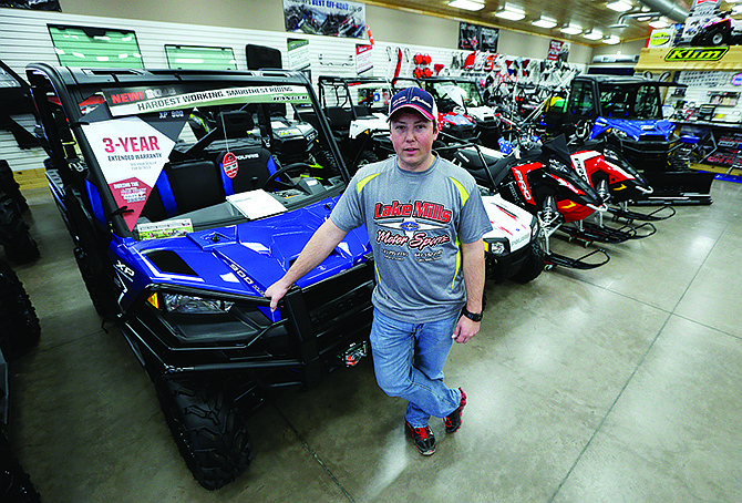 Michael Rygh stands near all-terrain vehicles Dec. 16 at his dealership in Algona, Iowa. The buzzy, open-air vehicles are supposed to be banned from roads in New York and other states. 
