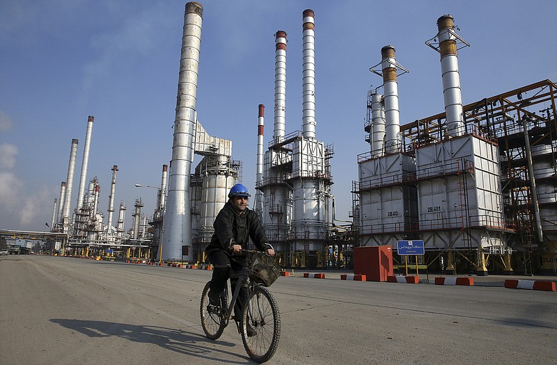 An Iranian oil worker rides his bicycle at the Tehran's oil refinery south of the capital. With a historic nuclear deal between Iran, the U.S. and five other world powers set into place this weekend, a European oil embargo on the world's seventh-largest oil producer will end. The most immediate fallout may be a steep drop in crude oil prices starting with the Asian market on Monday.