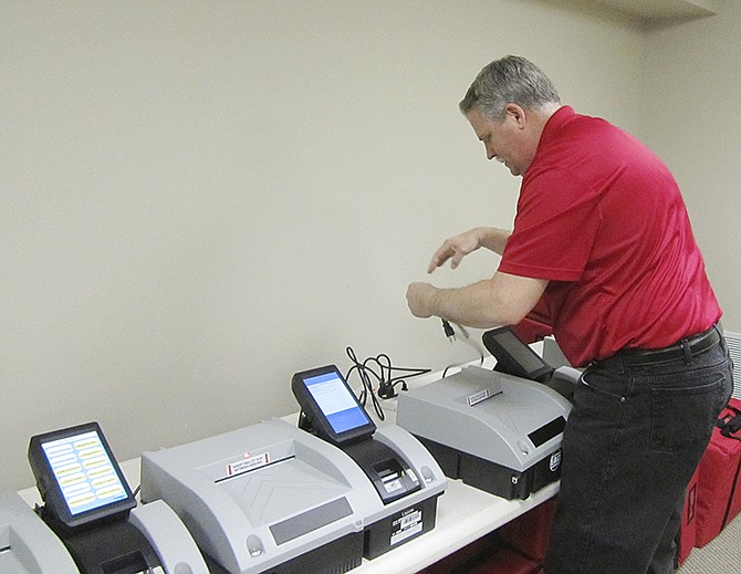 After unboxing new voting machines on Friday, Jan. 22, 2016, Cole County County Clerk Steve Korsmeyer plugs them in to verify they work and familiarize staff with the ballot scanners.