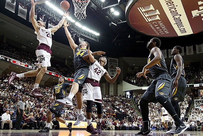 Texas A&M's Alex Caruso (21) goes after a rebound against Missouri's Ryan Rosburg (44) and Texas A&M's Tavario Miller (42) during the first half of an NCAA college basketball game, Saturday, Jan. 23, 2016, in College Station, Texas.  (AP Photo/Sam Craft)