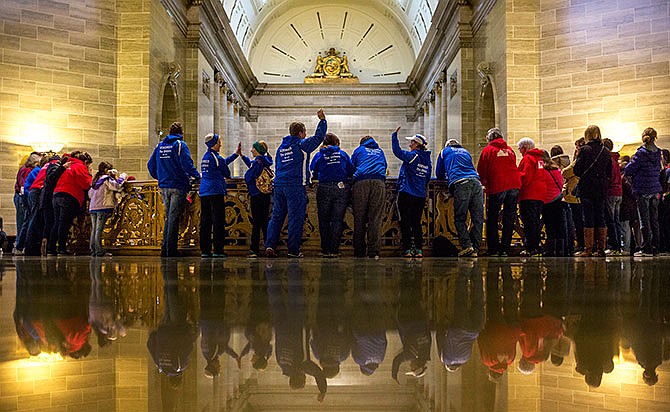 Members of LIFE Runners high-five each other while watching the fifth annual MidWest March for Life Rally last year from the third-floor balcony in the Capitol Rotunda.