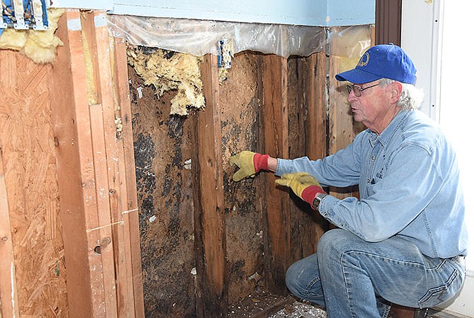 Mel Callahan talks about recent and past flood damage and the toll it's taken on the stud wall in the bottom level of Perry Redmon's Osage riverfront home, which had as much as 26 inches of water in it in December.