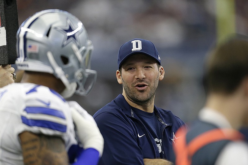 Dallas Cowboys' Tony Romo talks with teammates on the sideline in the first half of an NFL football game against the Washington Redskins on Sunday, Jan. 3, 2016, in Arlington, Texas. 
