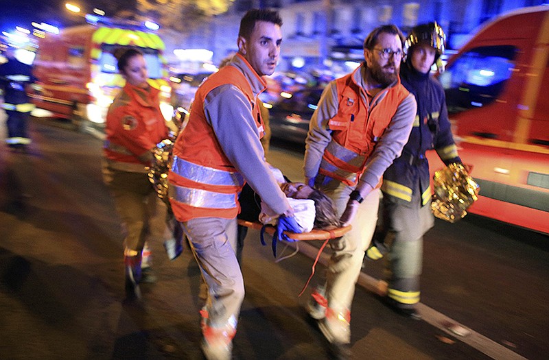 A woman is evacuated from the Bataclan concert hall after the IS terror attacks last November.