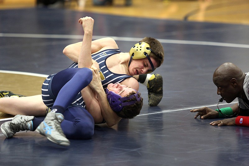 Zack Carr of Helias works on Hallsville's Trent Rowland during their 120-pound match Tuesday night at Rackers Fieldhouse.