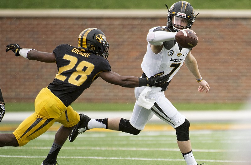 Missouri quarterback Maty Mauk (7) tries to escape the grasp of defensive back Logan Cheadle during the Tigers' spring football game on April 18, 2015, in Columbia.