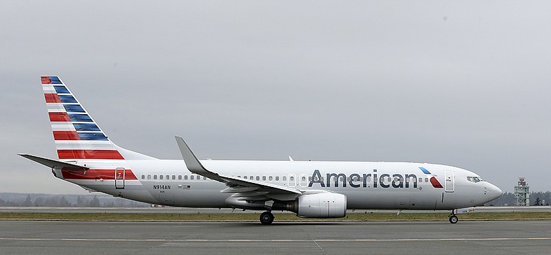 In this Tuesday, Jan. 26, 2016, photo, an American Airlines flight taxis at Seattle-Tacoma International Airport in Seattle. American reports financial results Friday, Jan. 29, 2016. 