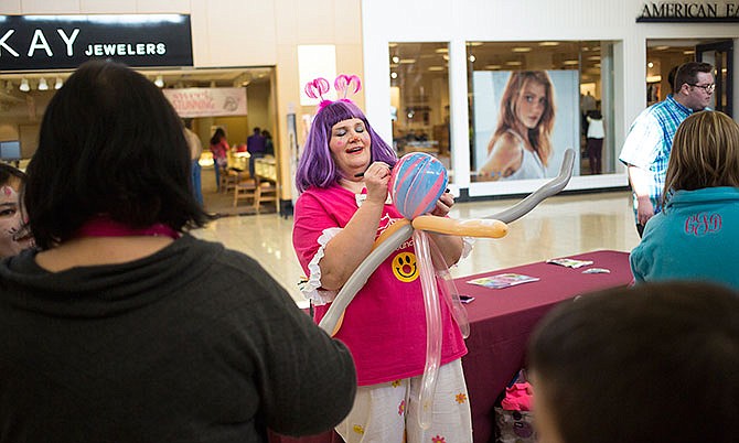Sassy the clown makes a balloon octopus for a participant in the recent Kids Day event at Capital Mall in Jefferson City. Attracting community events to the mall has been a priority according to owners Farmer Holding Company.
