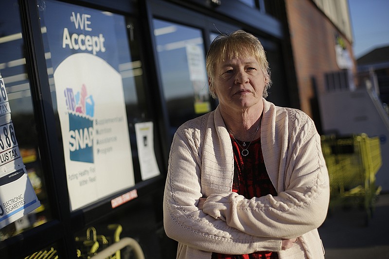 In this Jan. 29, 2016 photo, Terry Work stands outside a store that accepts food stamps in Bon Aqua, Tenn. Work's 27-year-old deaf son recently was denied disability payments, meaning he is considered able-bodied. And that means he stands to lose his food stamps, even though she said her son has trouble keeping a job because of his deafness. More than 1 million low-income residents in 21 states could soon lose their government food stamps if they fail to meet work requirements that began kicking in this month.