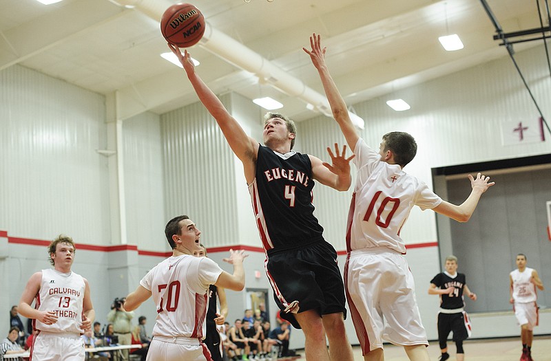 Eugene's Blake Rains drives the lane for a basket against the defense of Calvary Lutheran's Colin Bernskoetter (10) and Cal Kolzow (30) in the second quarter of Monday night's game at Calvary.