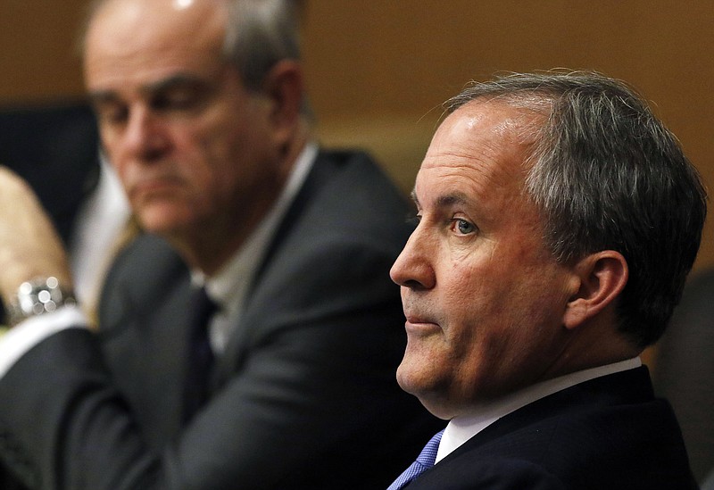 Texas Attorney General Ken Paxton, right, looks at one of the special prosecutors during a pretrial motion hearing on Dec. 1, 2015, at the Collin County courthouse in McKinney, Texas.