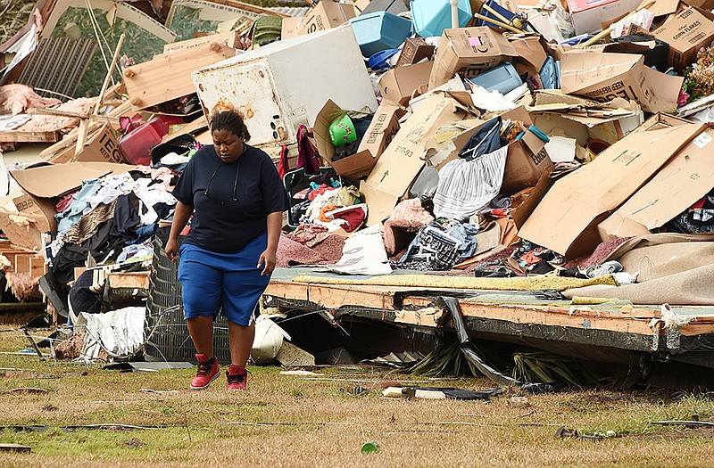 Shavone Hughes walks admist the devastation of her parents home near Aliceville, Alabama, after an EF2 tornado struck rural western Alabama and destroyed more than a dozen homes.