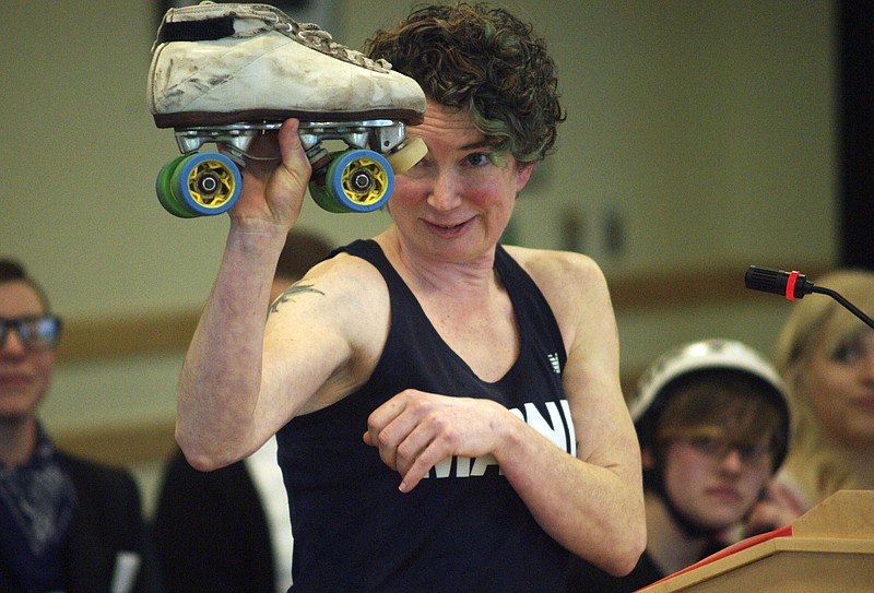 Christine "Betty B. Tough" Blais of Livermore Falls, Maine, holds up a roller skate Tuesday, Feb. 2, 2016, during a hearing by the The Committee on Labor, Commerce, Research and Economic Development at the State House in Augusta, Maine. She was one of the proponents to testify in favor of a bill that legalizes the bumps and hits that accompany the sport. Roller derby advocates said the old statute prohibits skaters from hitting each other, so skaters have been forced to break the law for the last 10 years in Portland.