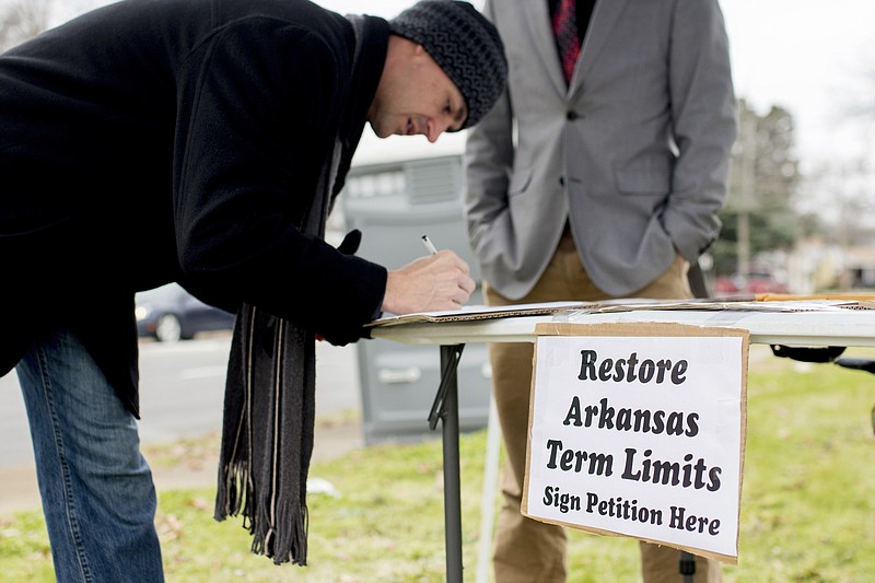Stuart Rubio, left, signs a petition Jan. 18, 2016, to limit lawmakers terms before the Martin Luther King Jr. Day parade in Little Rock. More than two decades after Arkansas became one of the first states to limit how long lawmakers could serve in the Legislature, Republicans who once championed the issue are conflicted. GOP leaders now say they believe lawmakers should be able to stay longer than originally planned.