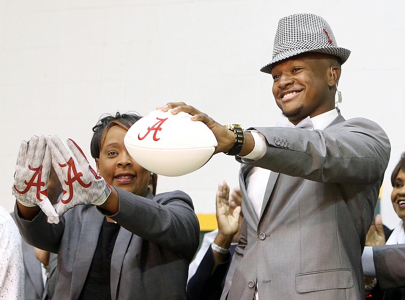 Gordo High School football player Ben Davis, with his mother Faye, left, holds up a football after committing to attend Alabama during a national signing day Program at Gordo High School, Wednesday, Feb. 3, 2016, in Tuscaloosa Ala.