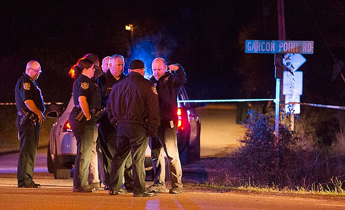 Authorities investigate a crime scene after a shootout in the Florida Panhandle, early Friday, Feb. 5, 2016 in Milton, Florida. A weeklong search for a Missouri couple wanted in a series of robberies and abductions across the South ended with one suspect dead and the other wounded Friday, after authorities say they chased the pair across the highway and through a rural neighborhood and exchanged gunfire with them in Florida's Panhandle. 