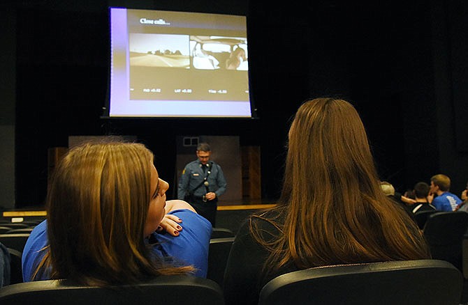 Bailey Clark looks around the auditorium to gauge reaction while students watch video clips of car wrecks during a safety assembly Monday at Cole County R-5 High School in Eugene. Clark was in a single-vehicle crash and surviving that has changed her mind about priorities while driving.