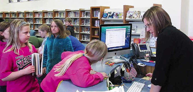 South Callaway media specialist Megan Nieland helps students of Whitney McCaulley's third-grade class check out books that are on par with the students' reading level Thursday. Nieland also allows students to check out an additional book regardless of lexile level to encourage them to pursue their interests.