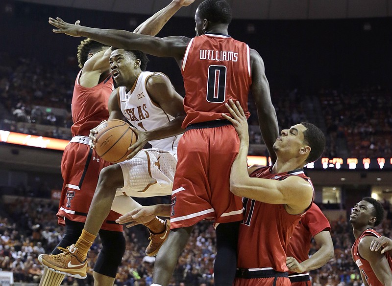 Texas guard Isaiah Taylor (1) drives to the basket through Texas Tech defenders Devaugntah Williams (0), Zach Smith (11) and Justin Gray (5) during the second half of an NCAA college basketball game, Saturday, Feb. 6, 2016, in Austin, Texas. Texas won 69-59. 